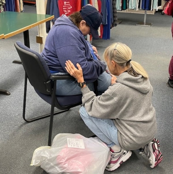 A Volunteer Praying for a Visitor